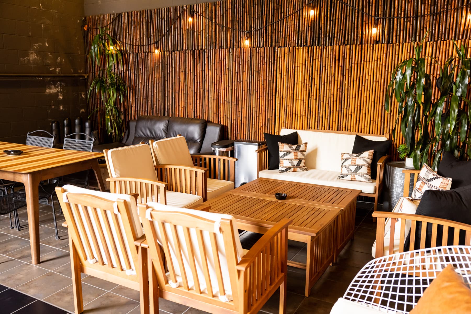 The covered outdoor patio behind Clear Lake — bamboo wall, string lights, and lounge seating.